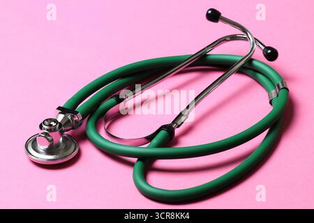 Top view of green stethoscope on colorful background. Medical diagnosis tool concept. Stock Photo