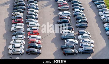 Aerial view of city parking lot with many parked cars in orderly rows, showing urban transportation, vehicle arrangement, and modern city planning. Stock Photo