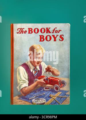 Vintage book cover showing a boy assembling a red toy car, titled 'The Book for Boys', against a teal background Stock Photo