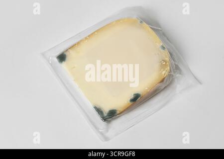 Sealed block of moldy goat cheese in packaging Stock Photo