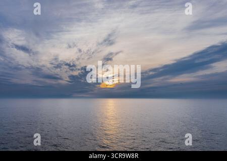 Beautiful sunset full of amazing natural colours seen over the North Sea during the summer solstice in Scandinavia, with the clouds creating a unique Stock Photo