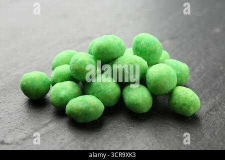 Pile of delicious wasabi coated peanuts on dark textured table, closeup Stock Photo