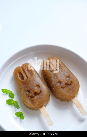 Homemade apple lemon mint popsicles isolated on a white plate Stock Photo