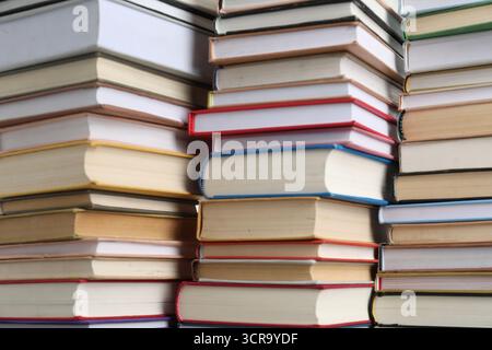Many different stacked books as background, closeup Stock Photo