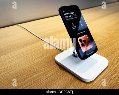 Manchester, UK - September 29, 2025: Sleek iPhone 17 Pro on a white charging stand in a store, highlighting tech and design in a retail setting. Stock Photo
