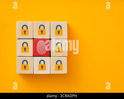Fingerprint replacing lock on wooden blocks on yellow background illustrating cybersecurity, biometric authorization and personal data protection Stock Photo