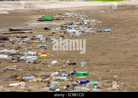 Discarded single-use plastic bottles and rubbish washed up on a remote coastline Stock Photo