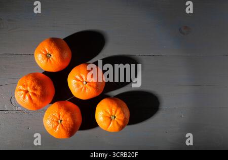 orange tangerine oranges on grey painted table top Stock Photo