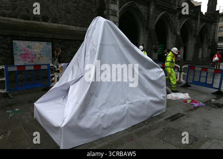 Dublin, Ireland  -  18th July 2014 - Workers in hard hats at near a covered up Molly Malone Statue on Saint Andrew's Street in Dublin city centre depicting street life in the Irish capital Stock Photo