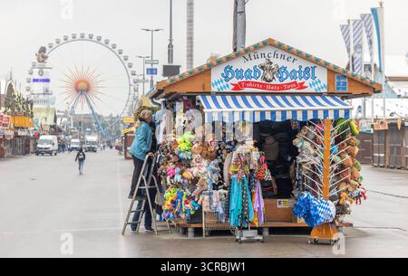 Eine Standlfrau bringt ihre Ware von außen mit einer Stehleiter an am Hut-Stand Münchner Huad Haisl am Morgen vor Eröffnung des Oktoberfestes bei verregnetem Wetter Wolken Regen Schlechtwetter auf der Wiesn Oktoberfest in München / Datum: 30.09.2025 / *** A stand woman brings her goods from outside with a stepladder to the hat stand Munich Huad Haisl in the morning before the opening of the Oktoberfest in rainy weather Clouds Rain Bad weather at the Oktoberfest Oktoberfest in Munich Date 30 09 2025 Stock Photo