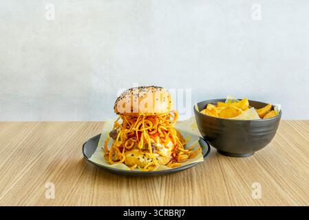 Gourmet burger with Galician blonde beef, melted smoked   cheese, RAF tomato, and romaine lettuce between toasted brioche buns with clarified butter Stock Photo