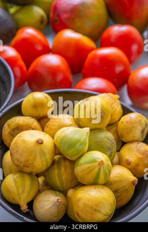 Still life where the organic shapes of figs, pears, avocados, potatoes, and nectarines create visual balance on a pastel blue background Stock Photo