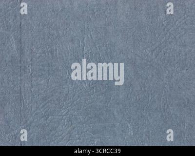 Blue-gray textured surface with intricate patterns resembling fine lines or veins. The texture is uneven. It's a close-up of an old cardboard map mean Stock Photo