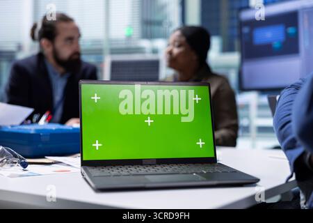 Production plant expert analyzes sustainable manufacturing research and development data using green screen laptop. Investors review documentation files on mockup notebook to evaluate tech innovations Stock Photo