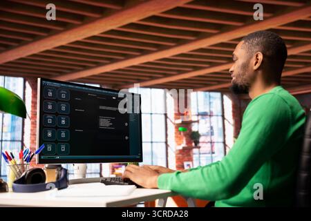 Man at home asks questions to AI LLM chatbot virtual assistant answering user prompts. African american person receiving information from artificial intelligence large language model program on PC Stock Photo
