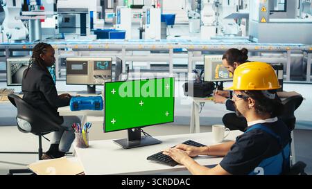 Photovoltaics factory engineer using green screen PC to adjust system parameters. Technician optimizing energy supply in solar panel manufacturing plant using chroma key computer, camera A Stock Photo