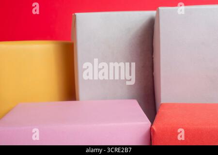 A vibrant assortment of square and rectangular gift boxes in pink, yellow, red, gray, and pastel colors create a festive packaging display. Perfect fo Stock Photo