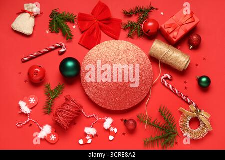 Beautiful composition with blank card, gift box, threads and Christmas decorations on red background Stock Photo