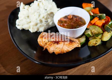 A view of a salmon dinner entree, featuring sautéed vegetables and mashed potatoes. Stock Photo