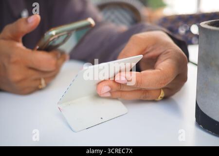 woman using smart phone to scan the cafe QR code to find the menu  Stock Photo