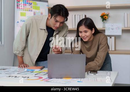 Creative UX UI Teamwork. Designers analyzing app designs on a laptop. Stock Photo
