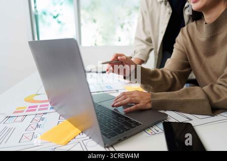 Collaborative UX UI Design Session with Laptop and Sketches Stock Photo