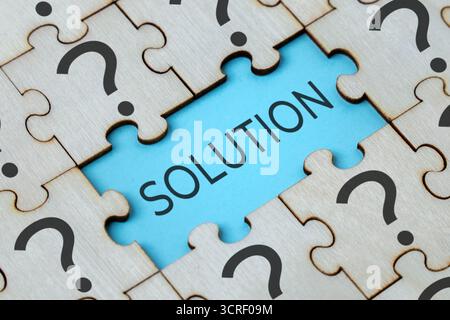 Jigsaw puzzle with black question marks and word SOLUTION. Problem, confusion and solution concept. Stock Photo