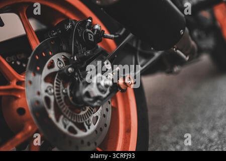 Padova, italy 1 october 2025: motorcycle rear wheel featuring an orange rim and detailed disc brake system, emphasizing precision engineering and spee Stock Photo