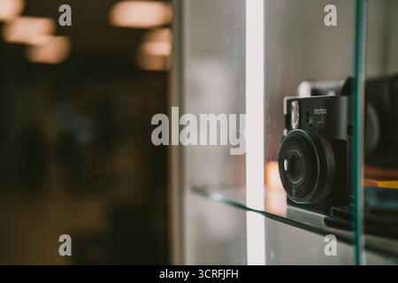 Padova, italy 1 october 2025: fujifilm instax instant camera displayed behind glass on a shelf, retro vintage style highlighting instant film photogra Stock Photo