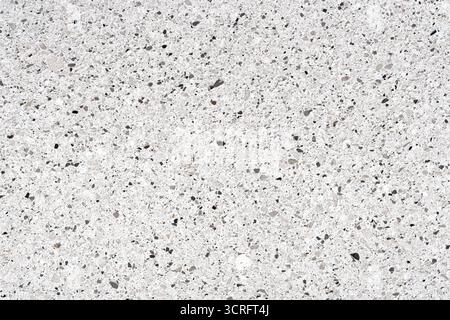 Close-up texture of white quartz surface with gray and black mineral speckles. Natural stone pattern with granular structure for backgrounds Stock Photo