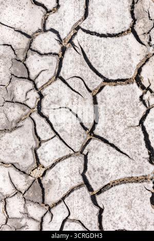 Cracked dry mud in a dried-up stream during a summer drought in Sicily, Italy Stock Photo