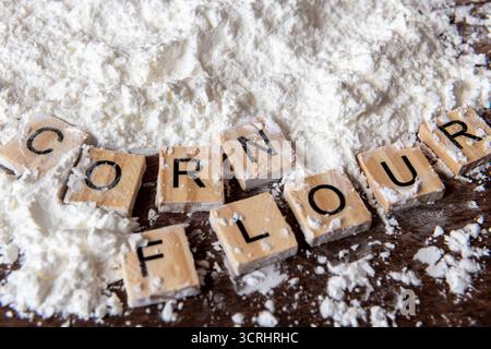 A close up of the words corn flour next to a heap of corn flour. Stock Photo