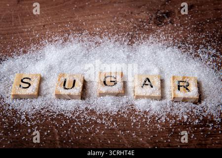 A close up of the word sugar sprinkled with granulated white sugar. Stock Photo