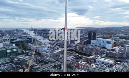 Dublin, Ireland - 01st October 2025 - A mysteriously erected Palestinian flag with a message about Gaza flies from the Spire Monument with Liberty Hall, the River Liffey and Dublin Bay visible in Dublin city centre depicting aerial view of the streets and buildings of the Irish capital Stock Photo