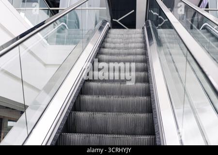 Modern escalator interior. Empty moving stairs in shopping mall. Transportation design background. Moving staircase detail closeup. Urban architecture Stock Photo