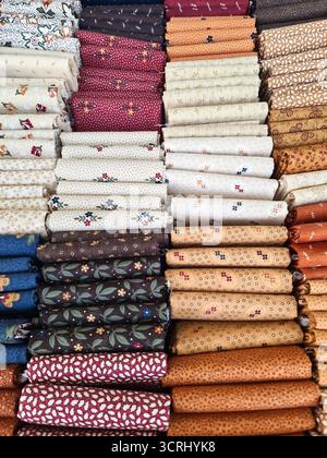 Cotton bundles displaying various floral and geometric patterns, ideal for quilting, sewing, and craft projects Stock Photo