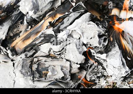 Burning paper documents. Fire flame with ash and smoke. Destroyed files background. Hot embers of burnt paperwork. Confidential information destructio Stock Photo