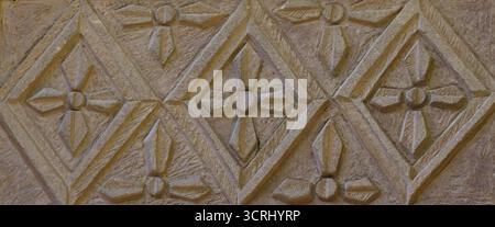 Carved stone panel with geometric and floral patterns showcasing historical architecture and detailed craftsmanship Stock Photo
