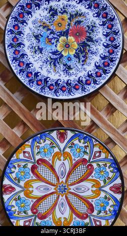 Vertical view of ceramic plate with colorful pattern hanging on a wall Stock Photo