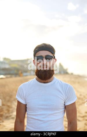 Portrait of handsome bearded man in shirt on the beach. Stock Photo