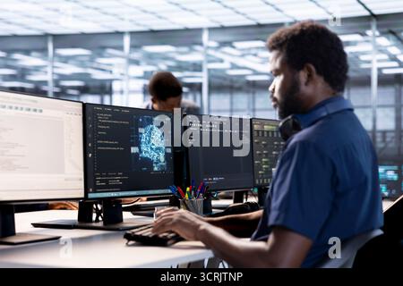 Data center professional doing AI research, implementing algorithms using machine learning. Computer scientist in server room workspace using artificial intelligence computational models Stock Photo