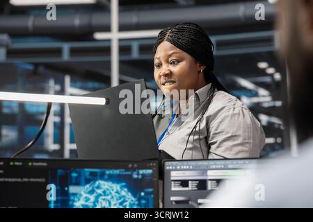 IT specialist raging after finding errors while inspecting neural network data center used for machine learning. Upset engineer angered by glitches found during maintenance on server hub Stock Photo