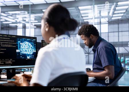 Server hub workspace IT professional using AI systems to input data faster and solve complex computational tasks. Data center worker using artificial intelligence parallel processing technology Stock Photo