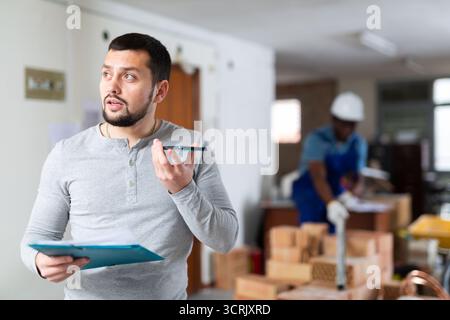 Construction manager with paper folder having telephone conversation Stock Photo
