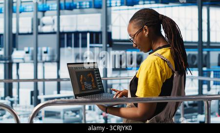 Engineers working in smart factory, collecting and analyzing data. Technicians using tracking software in industry 4.0 industrial plant equipped with advanced sensors, camera A Stock Photo