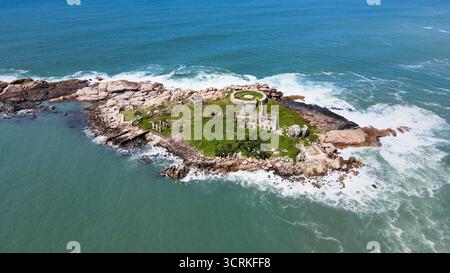 Aerial view of an old abandoned fortress in ruins from the 18th century on an isolated island full of rocks and vegetation surrounded by the sea Stock Photo