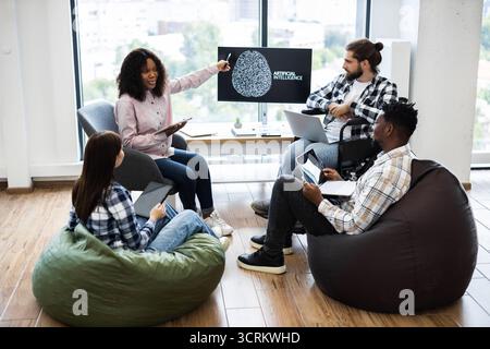 Colleagues collaborating on an artificial intelligence project in casual room Stock Photo
