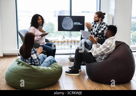 Team Discussing Artificial Intelligence with Enthusiastic Applause in Office Stock Photo