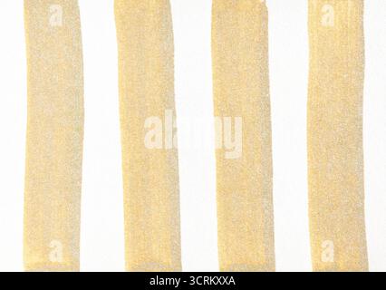 Vertical gold paint strokes on white background minimalist abstract art design. Stock Photo