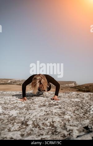 Woman Doing Push-Ups on a Rocky Cliff Stock Photo